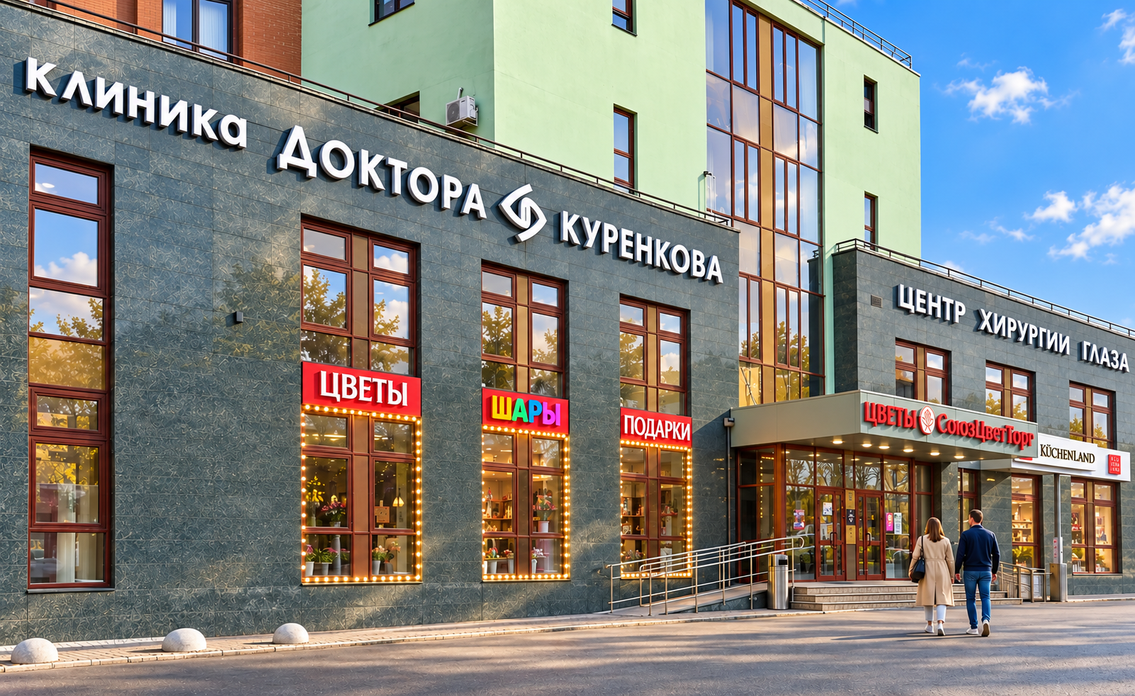 Солнечный фасад Клиники доктора Куренкова, пара идёт ко входу